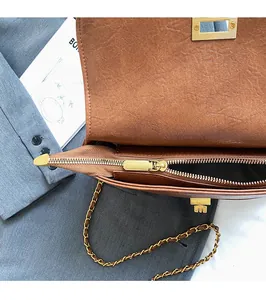Détail du zip en métal doré fluide et texture cuir marron d'un sac bandoulière chic