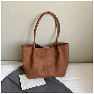Detail showing the brown suede texture and central seam stitching of the large tote bag