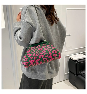 Detalle del bolso de punto con estampado de leopardo rosa y verde con cadena