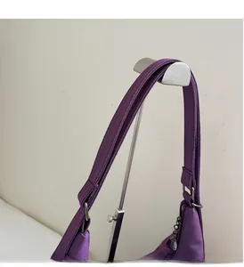 Close-up of durable padded handles and metal buckle on this purple nylon tote bag
