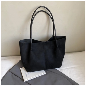 Detail view of large black suede tote bag showing soft texture and double handles