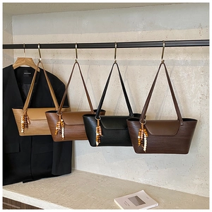 Dettaglio di quattro borse tote in pelle intrecciata in vari colori su eleganti espositori