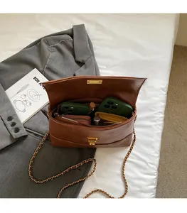 Vue détaillée montrant l'intérieur spacieux avec compartiments du sac en cuir marron