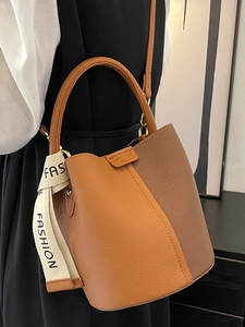 Modern caramel and dark brown bucket bag with lychee grain leather and fashion strap