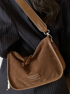 Braune Schultertasche aus Wildleder in Halbmondform mit breitem Gurt und Lederpatch