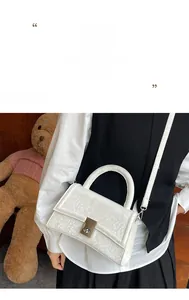 Detailed close-up of textured faux animal pattern leather on a white crossbody bag with chain