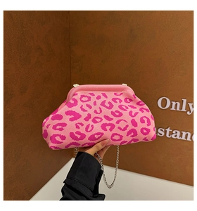 Détail d'une pochette en tricot à imprimé léopard rose avec une chaîne en métal argenté