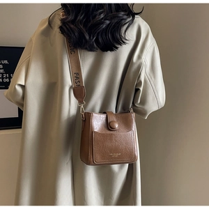 Détail du sac seau marron vintage avec une large bandoulière tissée logo FASHION