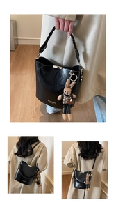 Detail of black PU leather bucket bag featuring woven handle and cute rabbit charm accessory