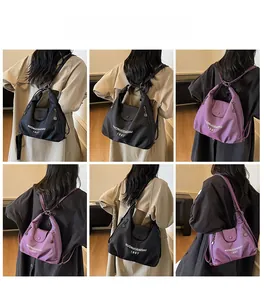 Detail view of large nylon tote bag in black and purple with multi-way shoulder straps