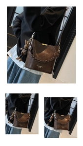 Detail of dark brown glossy PU leather bucket bag with woven handle and rabbit charm