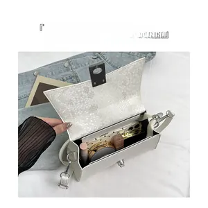 Top view of open white snakeskin hourglass bag with silver lock showing interior storage