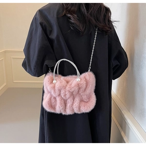Détail du sac nuage en fausse fourrure rose avec poignée en strass et perles sur manteau