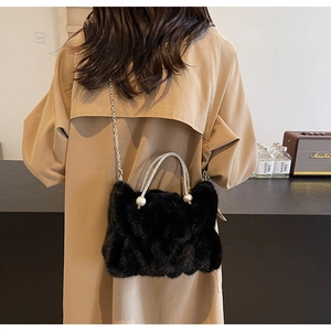 Détail du sac en fausse fourrure noire avec poignée en strass et accents de perles