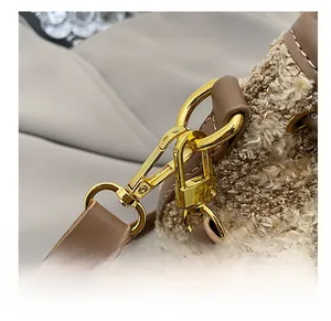 Detail showing golden metal hook, premium stitching on brown leather strap and plush fabric