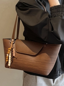 Borsa sottobraccio marrone intrecciata minimalista con patta in pelle e ciondolo di perline