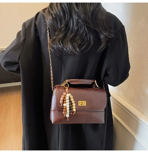 Détail du sac à main marron rétro avec fermoir doré et pendentif en perles multicolores