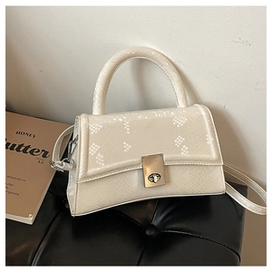 Detail of off-white handbag featuring snake-skin texture and silver metal twist lock