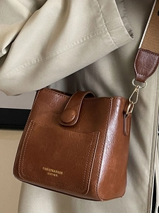 Sac seau vintage en cuir marron avec lettrage doré et bandoulière en toile élégante