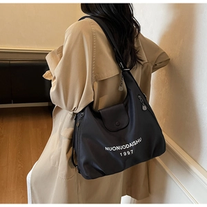 Detailed view of the black nylon tote bag showing its large capacity and printed lettering
