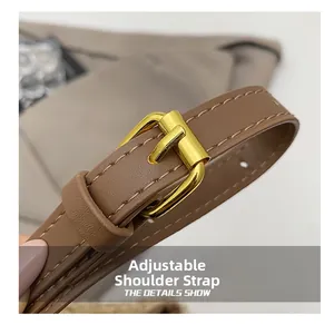 Detail of adjustable brown leather shoulder strap with gold buckle and stitching