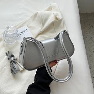 Detail of silver metallic underarm bag with brand embossing and detachable shoulder strap