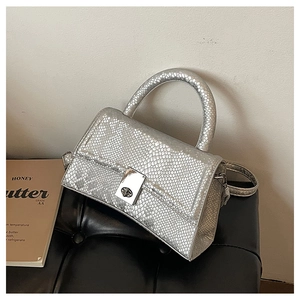 Close-up of silver snakeskin textured handbag with metallic twist lock and handle