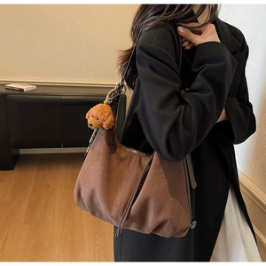 Brown suede-like tote bag detail featuring fringe tassels and a cute teddy charm