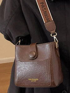Sac seau vintage marron foncé en cuir texturé avec large bandoulière tissée mode