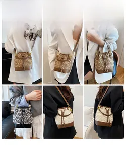 Detail view of woven tweed bucket bags in brown and black with leather drawstring trim
