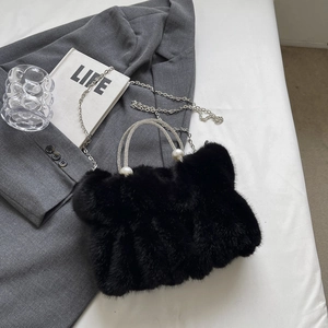 Détail du sac à main en fausse fourrure noire avec poignées en strass et perles