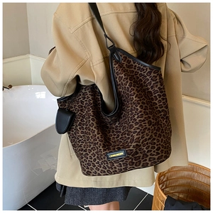 Gros plan du sac cabas léopard avec bordure en cuir noir et pochette suspendue
