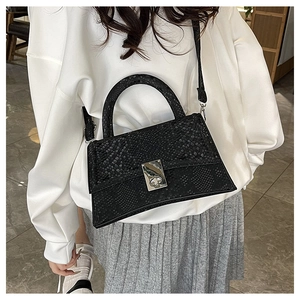 Detail of black snake embossed texture on trapezoid bag with silver metal lock