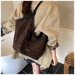 Détail du grand sac cabas imprimé léopard avec bordures en cuir noir et fine bandoulière