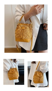 Detail showing bright yellow tweed and leather bucket bag with drawstring and tassels