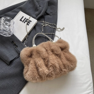 Détail du sac à main en peluche marron avec poignée en strass et perles blanches élégantes