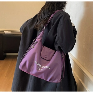 Detail view of the purple large-capacity nylon tote bag with front flap pocket and logo