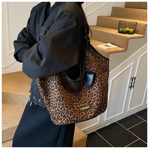 Vue détaillée du grand sac cabas à motif léopard avec poignée noire et pendentif décoré