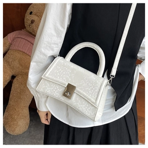 Detail view of white snake-embossed handbag featuring a curved base and silver square lock