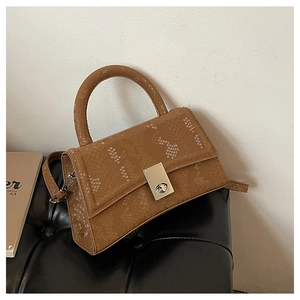 Detail of brown snakeskin pattern PU leather bag with silver turn-lock and handle
