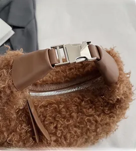 Détail du sac moumoute marron avec poignée en cuir et boucle en métal argenté brillant
