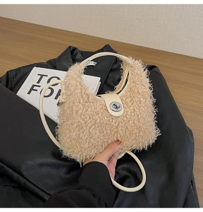 Dettaglio della borsa in peluche beige con chiusura a scatto argentata e morbida pelliccia sintetica