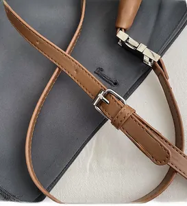 Détail macro de la bandoulière réglable en cuir caramel avec boucle en métal argenté