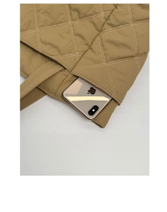 Detail der khakifarbenen Stepptasche mit Rautenmuster und praktischer Seitentasche