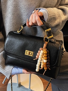 Sac à main vintage noir minimaliste avec fermoir tournant doré et breloque en perles