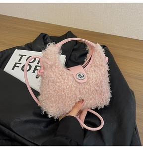 Dettaglio della borsa rosa in peluche con manico in pelle e chiusura a girello in metallo