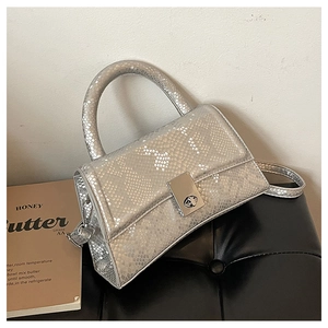 Detail of silver snake-patterned handbag with metallic turn-lock and scale texture