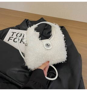 Dettaglio della borsa a tracolla in peluche bianca con chiusura argento su pelle nera