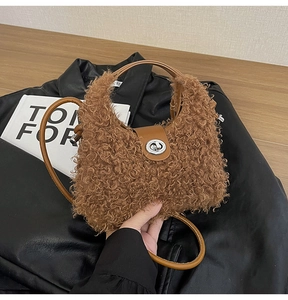 Dettaglio borsa a mano in peluche marrone con finiture in pelle e chiusura a scatto