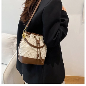 Close-up of contrast bucket bag featuring white fleece texture and brown leather details